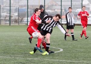 Liam Martin battles for the ball during horrendous conditions in the inter-island Parish Cup against Whalsay. 